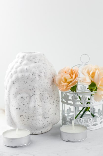 White ceramic figurine Buddha head  ,decorative cage with flowers and candles
