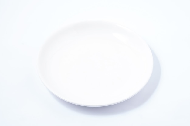 Photo white ceramic plate on a white table. for food, advertising space.