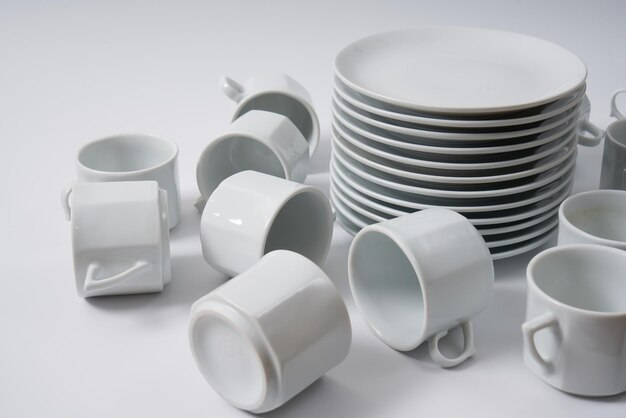 White ceramic plates and coffee cups on a white background