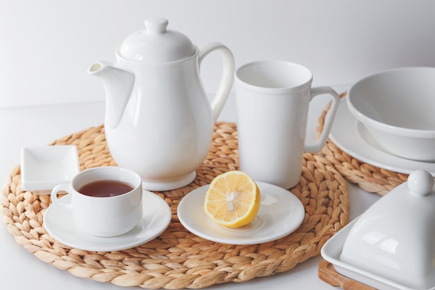 white ceramic tableware, fibre braided round placemat and cutlery set on white background. scandinavian style