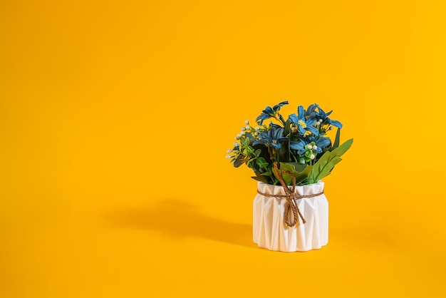 White ceramic vase with flowers on orange background