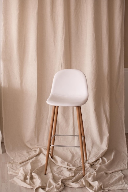 White chair with long wooden legs in the interior