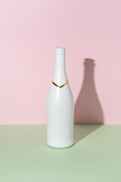 Белая бутылка шампанского на ярком фоне.