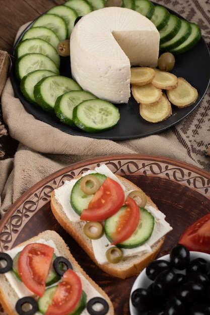 белый сыр и нарезанные огурцы с бутербродами