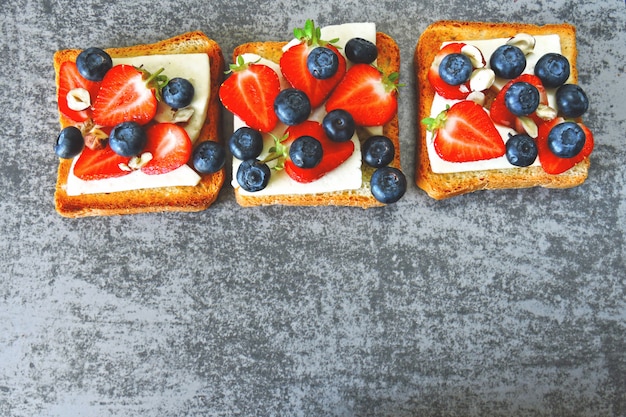 White cheese, strawberry, blueberry. Toasts with white cheese, blueberries and strawberries.