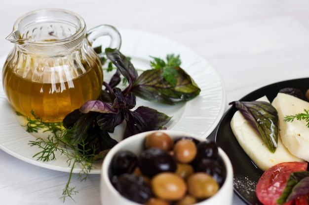 White cheese with tomatoes, green and black olives, basil, coriander and olive oil 