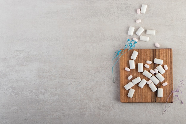 White chewing gums placed on a stone table .