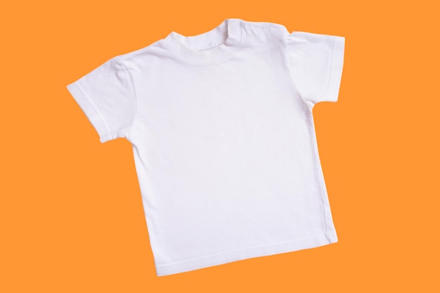 White children's tshirt mockup for logo text or design on wooden isolated on orange