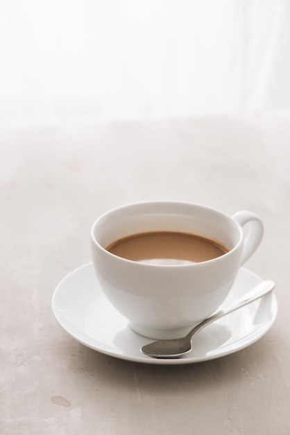 White china cup of tea with milk 