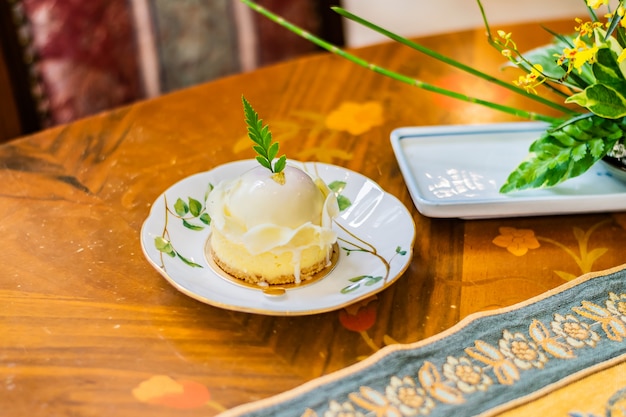 高級テーブルクロスと木製のテーブルの白い皿にベリーケーキとホワイトチョコレートの盛り合わせ