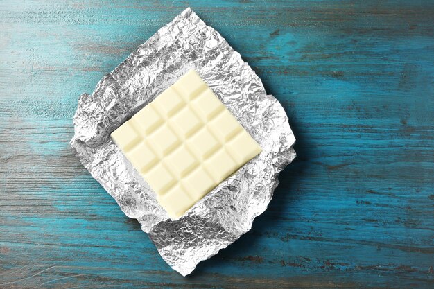 white chocolate bar in foil on gray background