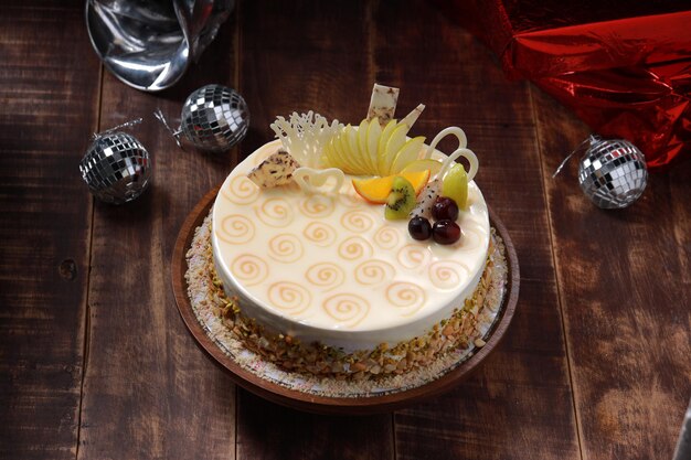 White Chocolate cake arranged on a rustic wooden background with gifts placed nearby.