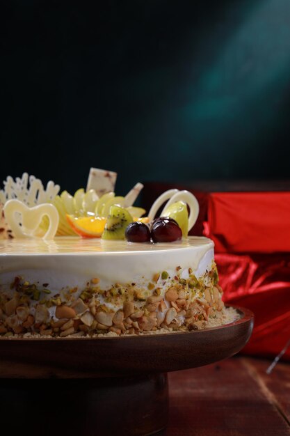 White Chocolate cake arranged on a rustic wooden background with gifts placed nearby.