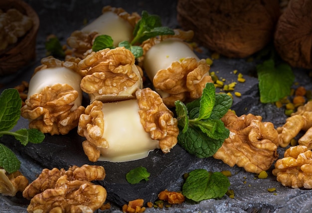 white chocolate candies and marzipan and walnut filling on a dark background with reflection