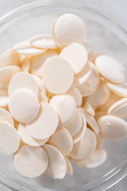 White chocolate chips in a small glass bowl on the kitchen counter