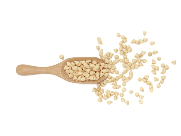 White chocolate chips with wooden spoon on white background. 