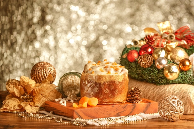 White chocolate panettone with dried apricot on wooden table with christmas ornaments