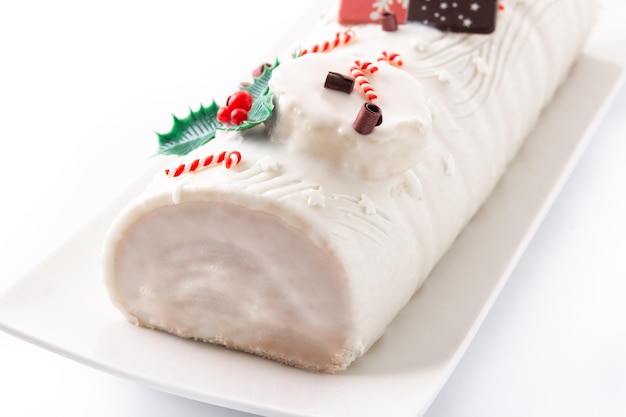 Torta di ceppo di natale al cioccolato bianco con ornamento di natale isolato su sfondo bianco