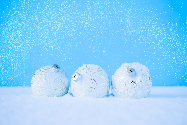 Foto palle di natale bianche su neve bianca