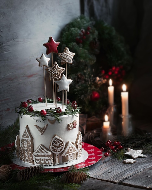 white christmas cream cake with gingerbread decor on wooden table background.