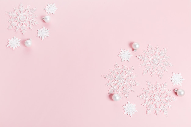 White Christmas holiday composition. Festive creative white pattern, xmas decor holiday ball with snowflakes on pink background. Flat lay, top view