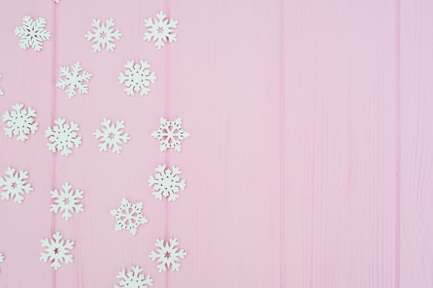 White christmas snowflakes decoration on pink wooden 