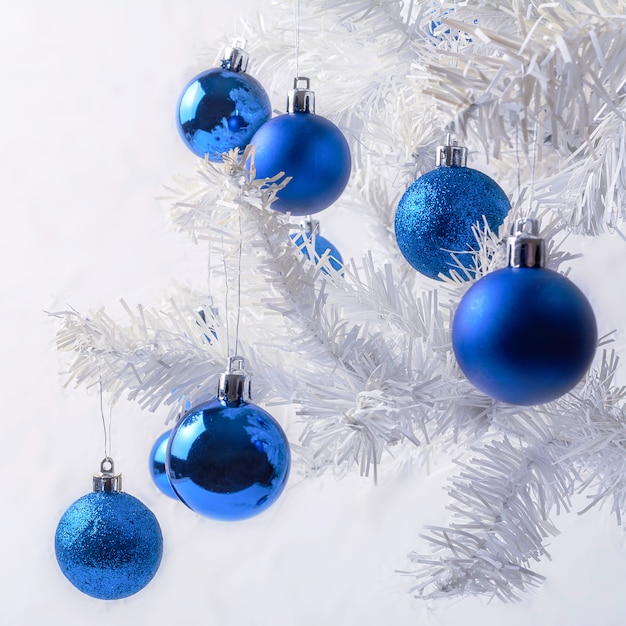 White Christmas tree branch with royal blue ornaments