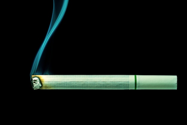 White cigarette is burn on black background