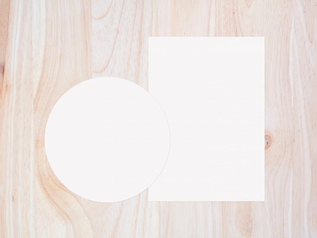 White circle paper and blank white paper on vintage brown wooden background. top view