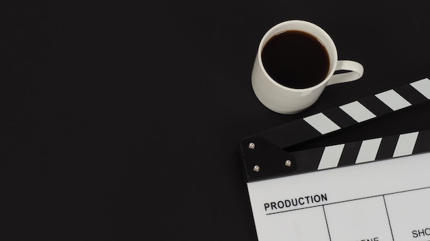 White Clapper board or movie slate and hot coffee white cup on black backgroundx9xDxA