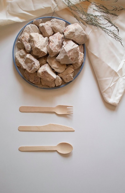 White clay stones with a wooden fork spoon and knife on a white background