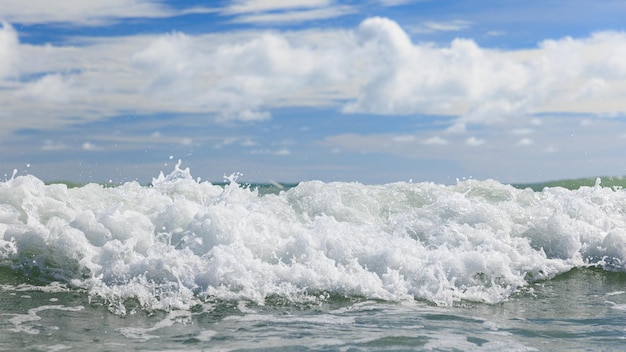 Foto onde bianche e pulite del mare della spiaggia tropicale con cielo blu e nuvole in una colorata giornata di sole scena di vacanze estive e vacanze concetto di viaggio d'affari strati di spruzzi d'acqua e sfondo del cielo