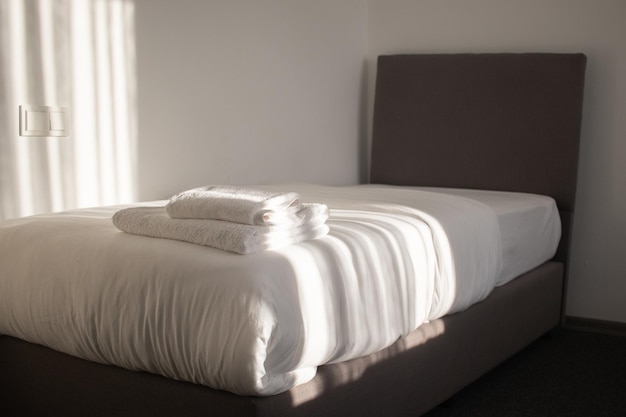 White clean towels stacked on the hotel bed. High quality photo