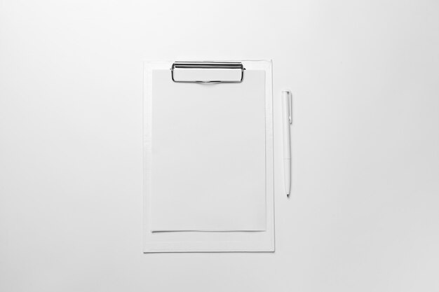 White clipboard with blank sheet of paper and pen