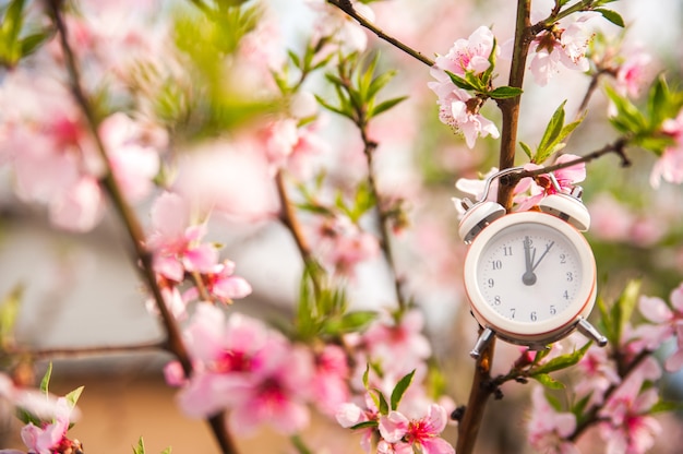 White clock and flowers as a postcard for the holiday.