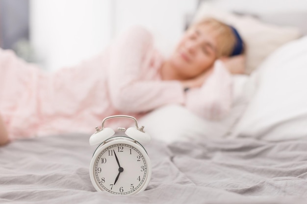 Photo white clock and sleeping woman