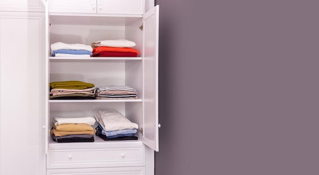 White closet in which things are neatly folded Copy space gray background