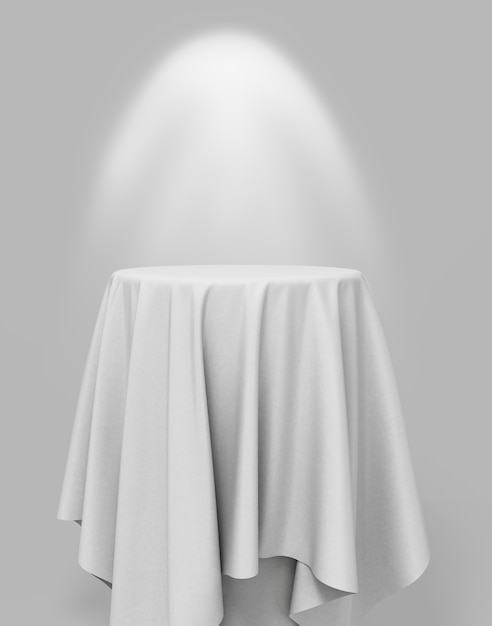 White cloth on a round pedestal on a gray background with illumination