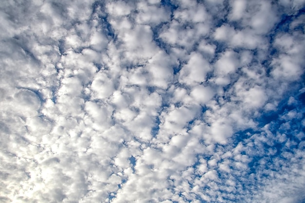 太陽の光と青い空を背景に白い雲