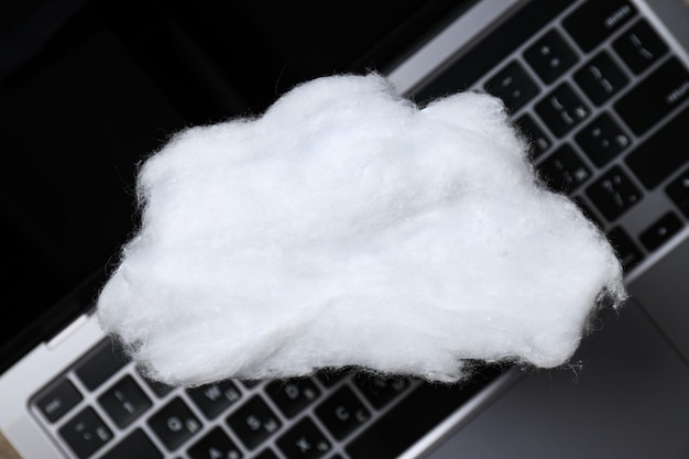 A white cloud made of cotton wool on a laptop keyboard