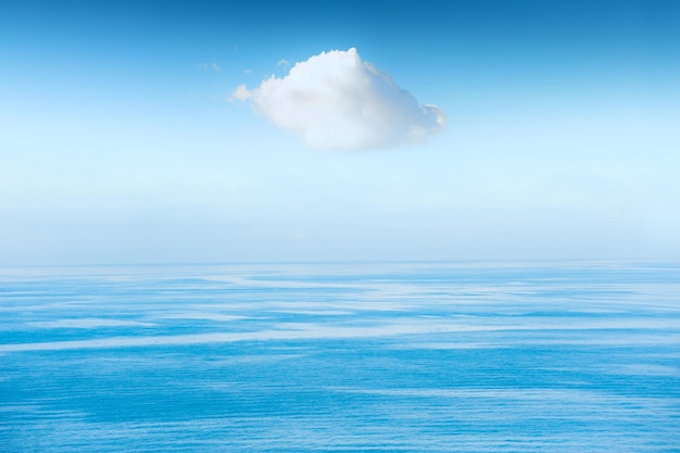 White cloud in the sky over the blue sea. Beautiful seascape, summer nature background. Calm and tranquility concept