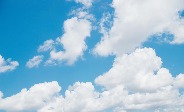 White clouds of air against a blue sky A clear day and good weather The sun is shining brightly Spring or summer day