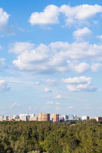 Foto nuvole bianche nel cielo blu sopra la città e boschi verdi