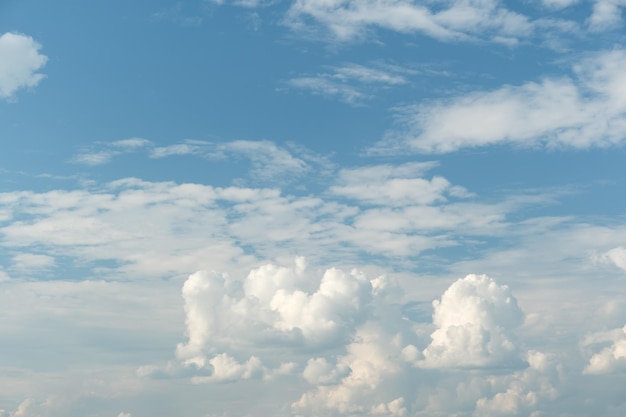 Белые облака имеют причудливую сельскую форму. Небо облачно и голубое.