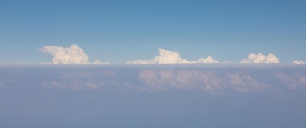 青い空を背景に地平線上の白い雲