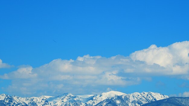 白い雲と雪の山の美しいパノラマ風景 青い空と白い雲のタイムラプス