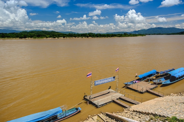 White clouds with a blue  sky,Long tail boat moored at the MEKHONG River