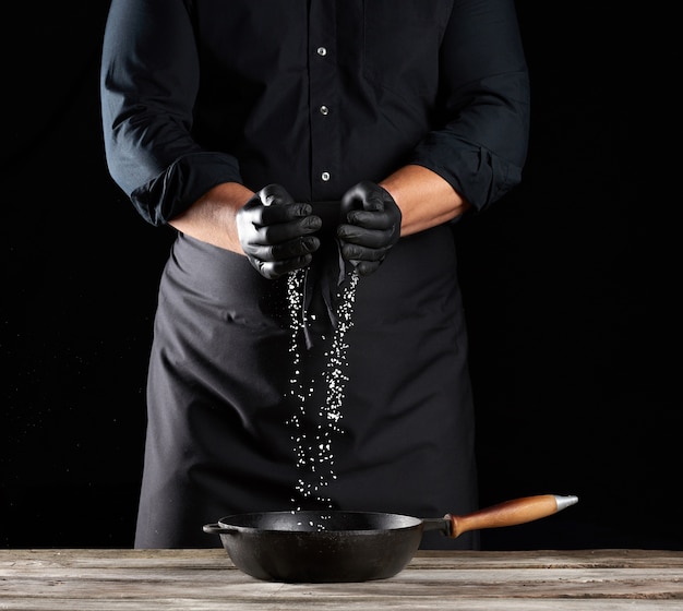 White coarse salt is poured from the chef's palms