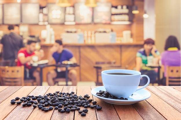 White coffee cup and coffee beans on wood table