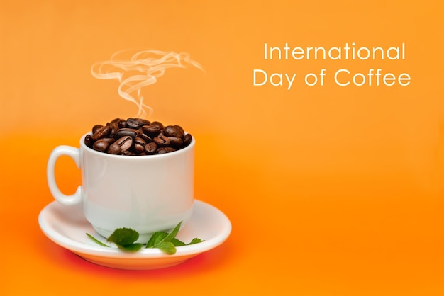 White coffee Cup full of coffee beans on an orange background with smoke on top The concept of international coffee Day